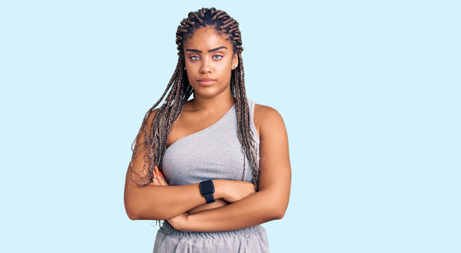 Young african american woman with braids wearing sportswear skeptic and nervous, disapproving expression on face with crossed arms. negative person.
