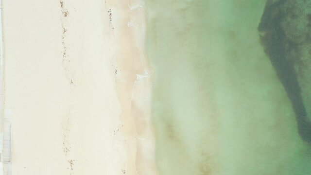 
Aerial shot beach on which the waves of the middle sea crash. Beautiful background landscape art video landscape where you can see blue water with waves and sandy beach.