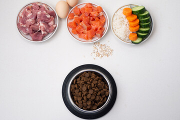 Dry pet dog food in bowl with natural ingredients. Raw meat, fish, vegetables, eggs and salad. concept of correct balanced and healthy nutrition for pet