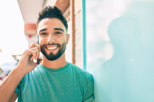 Young arab man with serious expression talking on the smartphone at the city.