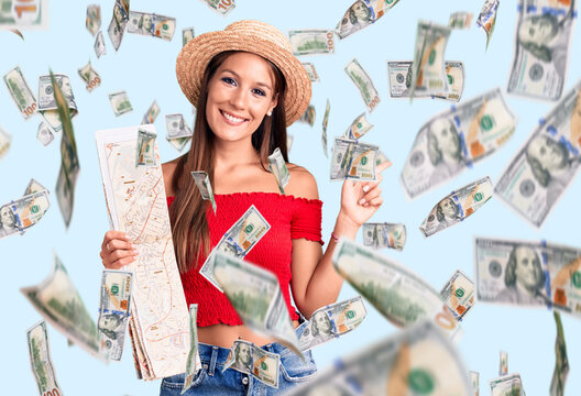 Young beautiful hispanic woman wearing summer hat holding city map smiling happy pointing with hand and finger to the side