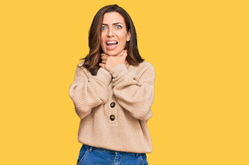 Young brunette woman wearing casual winter sweater shouting and suffocate because painful strangle. health problem. asphyxiate and suicide concept.