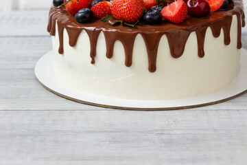 Piece of delicious cake with fresh berries, fruits and chocolate ganache.