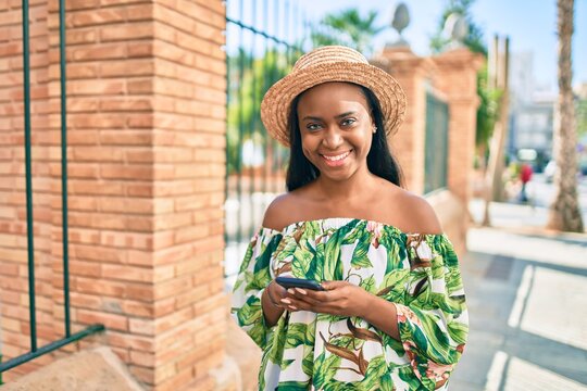 Young african american tourist woman on vacation smiling happy using smartphone at the city.