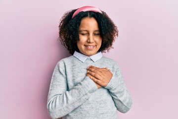 Hispanic little girl wearing casual clothes clueless and confused expression with arms and hands...