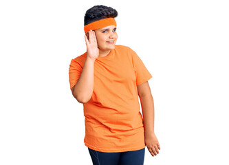 Little boy kid wearing sportswear smiling with hand over ear listening an hearing to rumor or gossip. deafness concept.