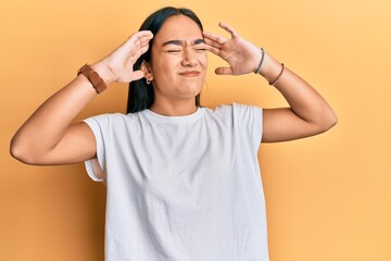 Young asian woman wearing casual white t shirt with hand on head, headache because stress. suffering migraine.