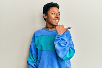 African american woman with short hair wearing casual sweatshirt smiling looking confident at the...