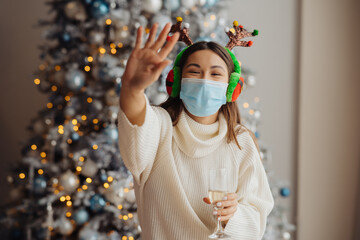 Beautiful young woman in protective mask with glass of champagne