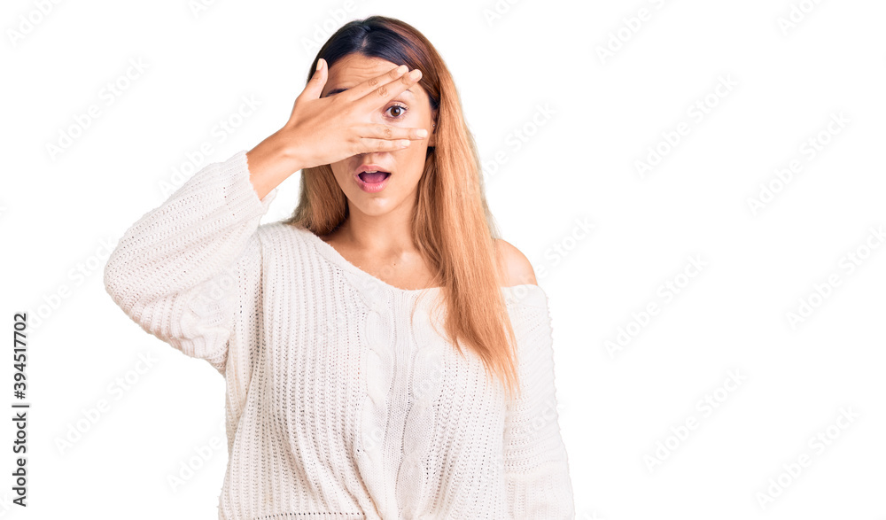 Sticker Beautiful young woman wearing casual clothes peeking in shock covering face and eyes with hand, looking through fingers with embarrassed expression.