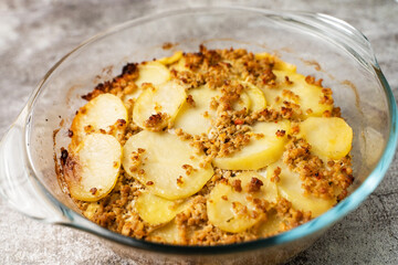 Close up on moussaka greek traditional meal with potatoes and meat in the glass pot on marble table