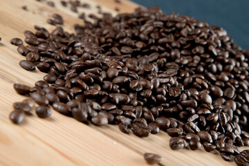 Café negro en grano sobre madera y en un recipiente de cristal 