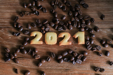 Top view of 2021 bread number and with coffee beans on wooden table. Happy new year 2021, Holidays food art concept. (close up)