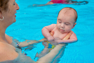 Newborn baby in the mother's arms in the pool
