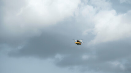 Fototapeta premium flying on a sky delivery drone with holding a .cardboard parcel