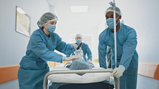 Group of hurrying paramedic multi-race doctors start to run in hospital corridor worry to save patient's life. Emergency department. Healthcare.