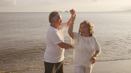 Asian couple senior elder retire resting relax dancing at sunset beach