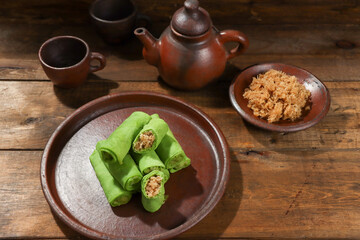 Dadar Gulung or Dadar Unti is Indonesian traditional finger food (jajan pasar), is grated coconut sweetened with palm sugar wrapped in pandan crepes.