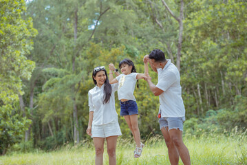 Happy asian family with daughter playing and travel in forest on weekend