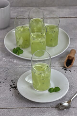 Puding es Kuwut. Pudding ice kuwut traditional dessert from indonesia made from coconut water, honeydew, coconut, basil seeds and lime.