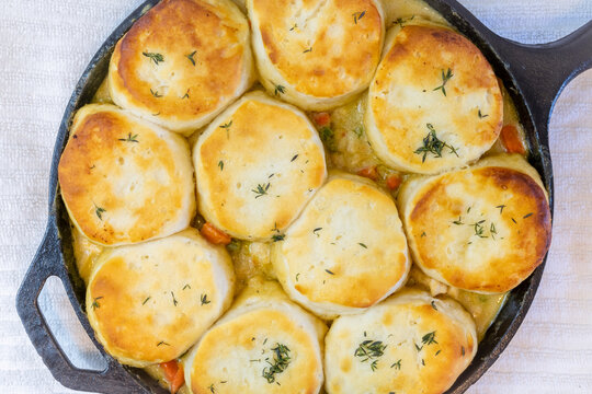 Top view of Chicken Pot Pie with biscuits used on top cooked to a toasty golden brown in a cast iron skillet.
