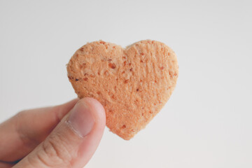 Tiny heart shape of bread in hand. Concept of love and care in Valentine day.