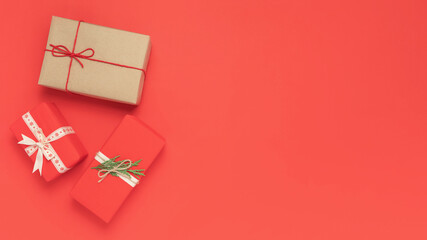 Christmas flat lay design for invitations. New Year holidays concept. Craft-wrapped gifts decoration in vintage style on a red background with place for text.
