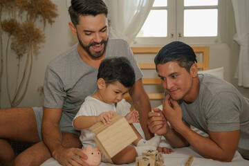 caucasian lgbt gay couple playing with their adopted son at home