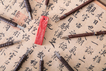 Looking down and shooting a seal surrounded by many carving knives on a calligraphy work