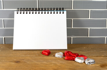 Blank spiral notepad in a modern kitchen with silver and red heart chocolates