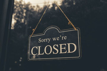 SORRY WE ARE CLOSED - Close sign broad hanging front of entrance door with copy space at coffee shop or restaurant