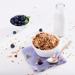 Muesli with blueberris in a bowl   on white wooden background. Delicious and healthy breakfast.