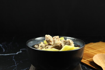 Soup of cutting fresh bitter melon with mushroom and pork rib in the bowl. Famous traditional soft and hot breakfast menu in Asia restaurant. High nutrition and vitamin for easy digestion. 