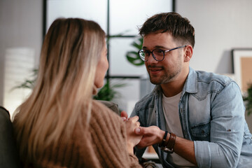 Young couple sitting and talking at home. Loving couple on a date.