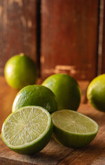 Limones sobre una tabla de picar y un limón partido a la mitad delante