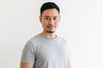 Happy and confident Asian man in grey t-shirt on isolated white background.
