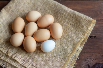 Rustic chicken eggs on a dark wooden background.