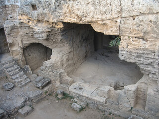 Ancient catacombs in Cyprus. Underground cave rooms, steps, stone walls are visible. Paphos.