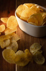 Chips de banana frita regados sobre la mesa iluminados por la luz de la tarde