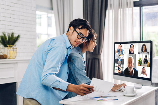 Young asian couple talk speak using desktop computer working and video conference meeting online chat.Creative business couple talk video chat call with colleagues at home.work from home concept