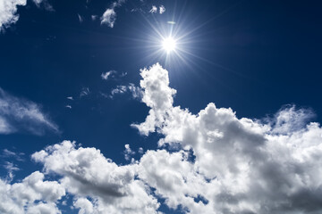 Fototapeta Niebieskie niebo i słońce między chmurami  obraz