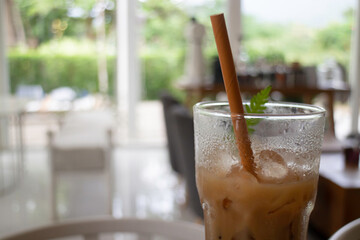 Iced coffee in glass with paper straw