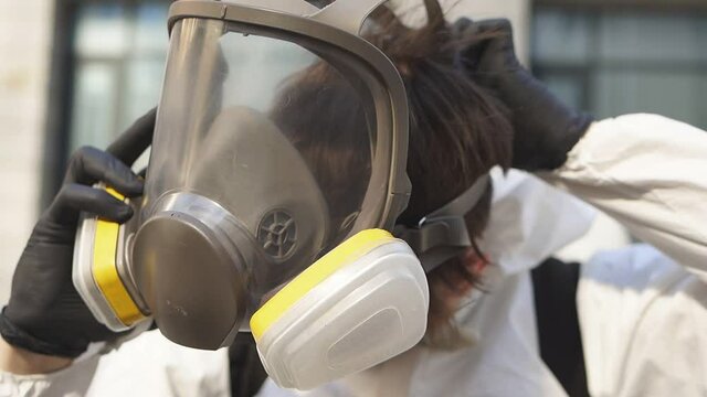 Young street disinfection company employee wears a protective mask.