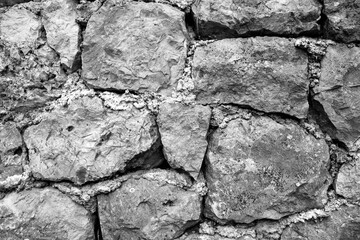 evocative black and white image of wall with stones

