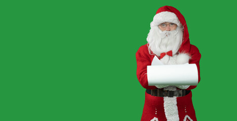 santa claus on a green background holding a list of children. Surprised face. Copy space.
