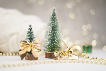 Two little Christmas trees decorated and gifts for the new year on the bokeh background, new year mood 2021