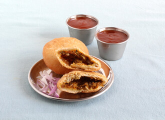 Kachori, a delicious and an Indian vegetarian deep-fried dish, with its shell made from flour dough and filled with items like chopped onion, red chili powder, and cumin seeds.