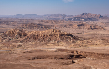 Colorful landscape of a remote desert region. Panoramic view of sandy hills, dry wadies, rock formations and boulders.
