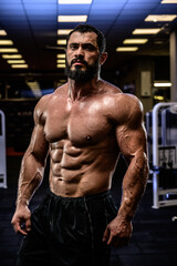 Fototapeta na wymiar strong man with perfect sport healthy body physique in dark fitness club gym