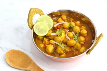 Indian food. Fresh chickpea masala, Chole masala curry, traditional north Indian dish. Popular Amritsari Chole bhature. Chana masala Garnished with lemon and onion. food photography. Copy space.